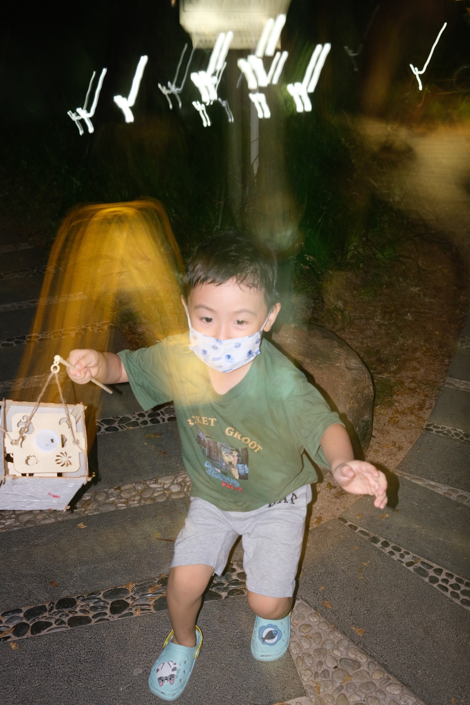 儿子提着灯笼冲向镜头，身后拖着光影