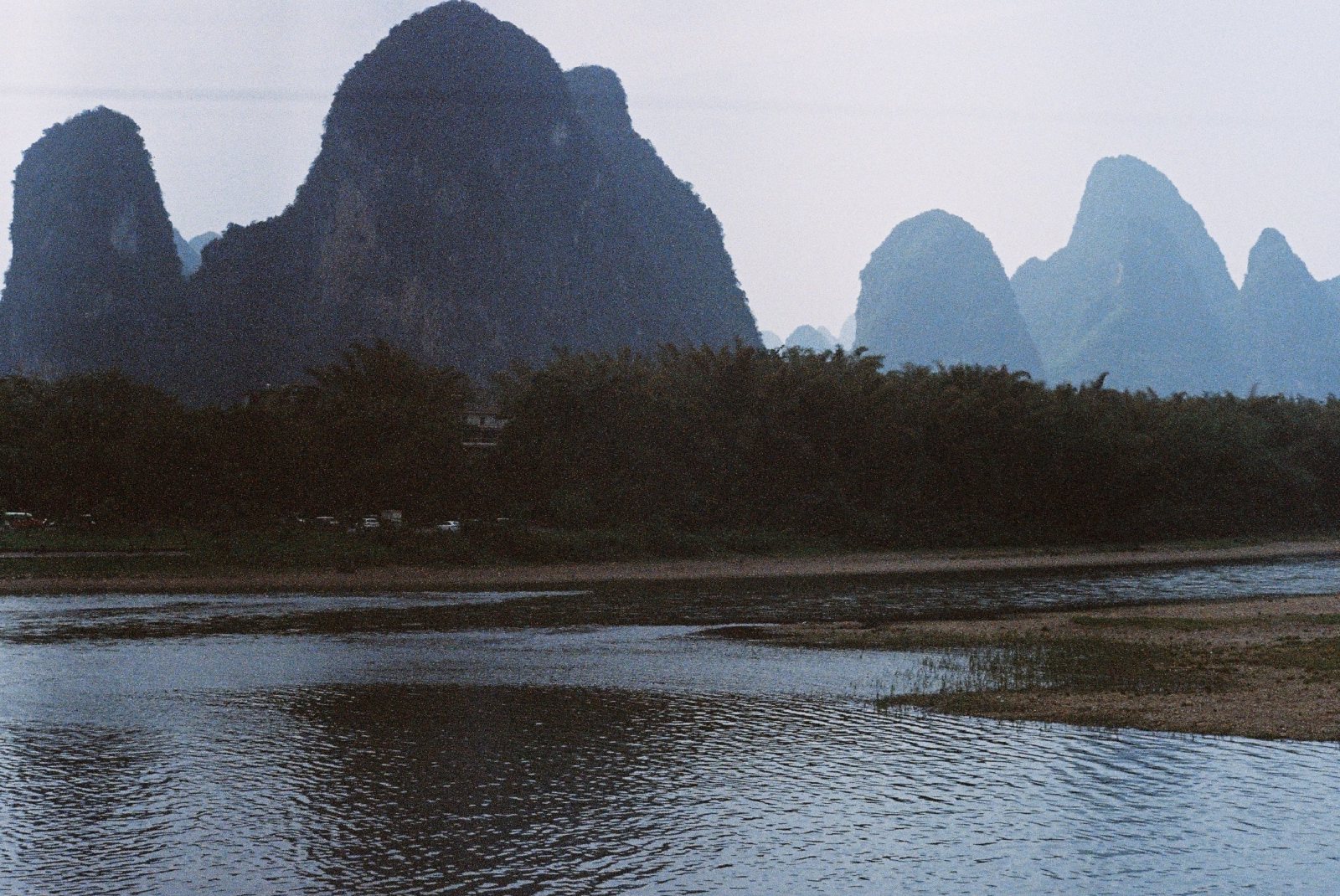 江对岸一排山峰和树林，倒影在水里