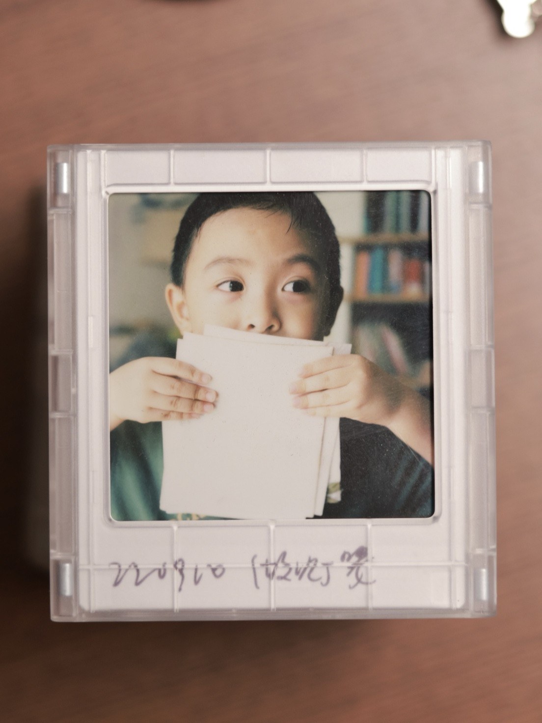 儿子两手举着一张纸挡住嘴