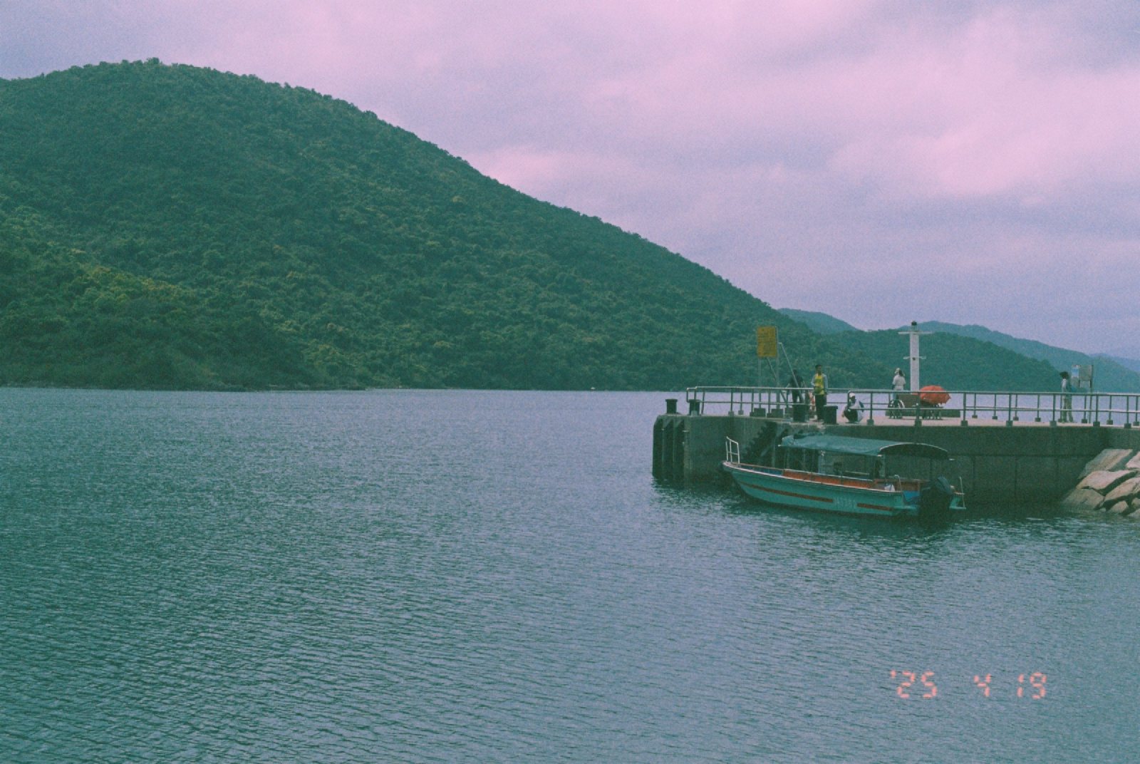 海湾和绿色的山，一座浮码头停着船