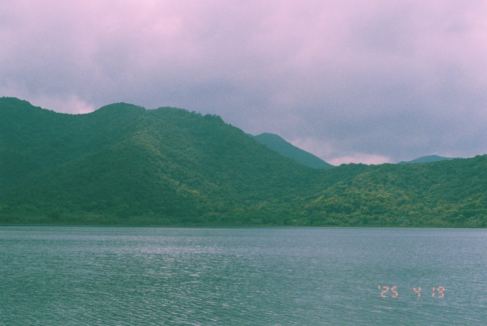 平静的水面，对岸是连绵的山