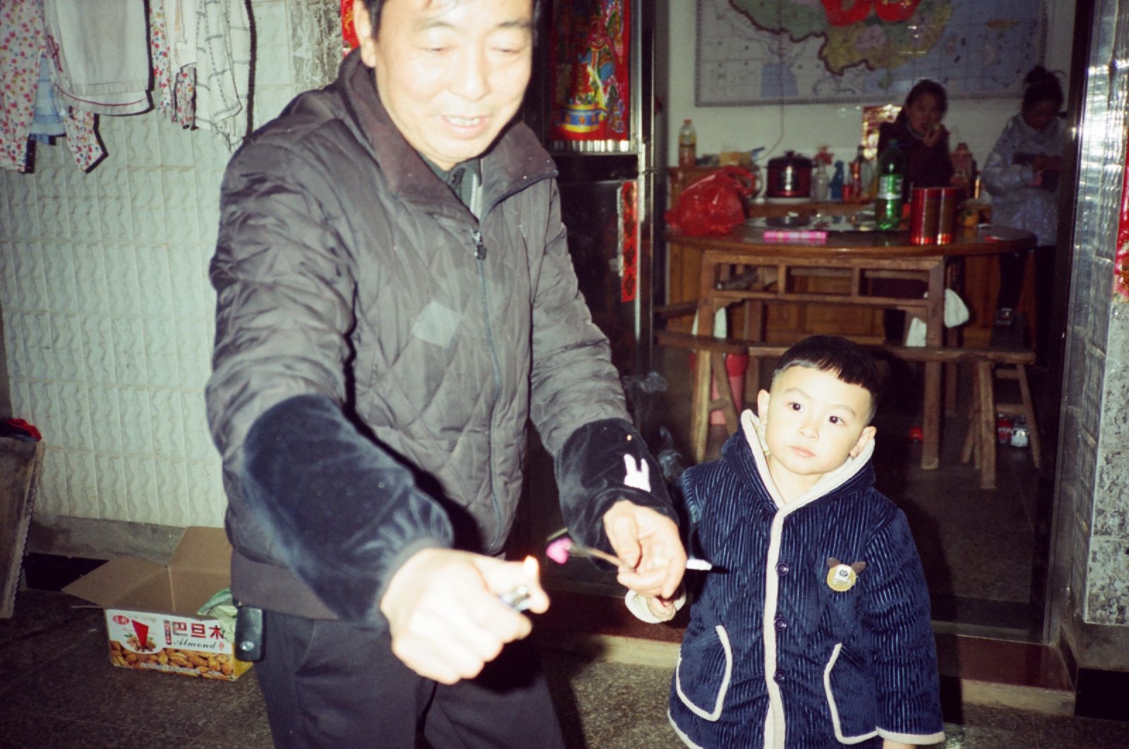 亲戚拿仙女棒给儿子，屋里是年夜饭的桌子