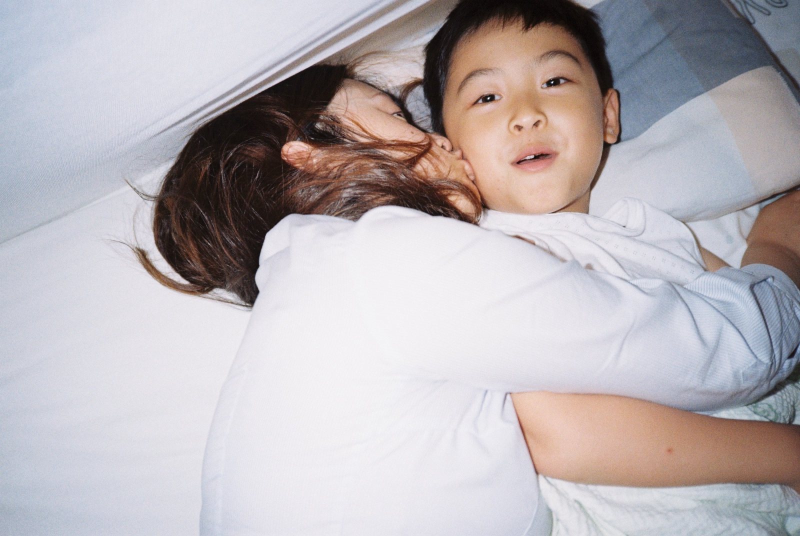 妈妈亲儿子，儿子张嘴看镜头