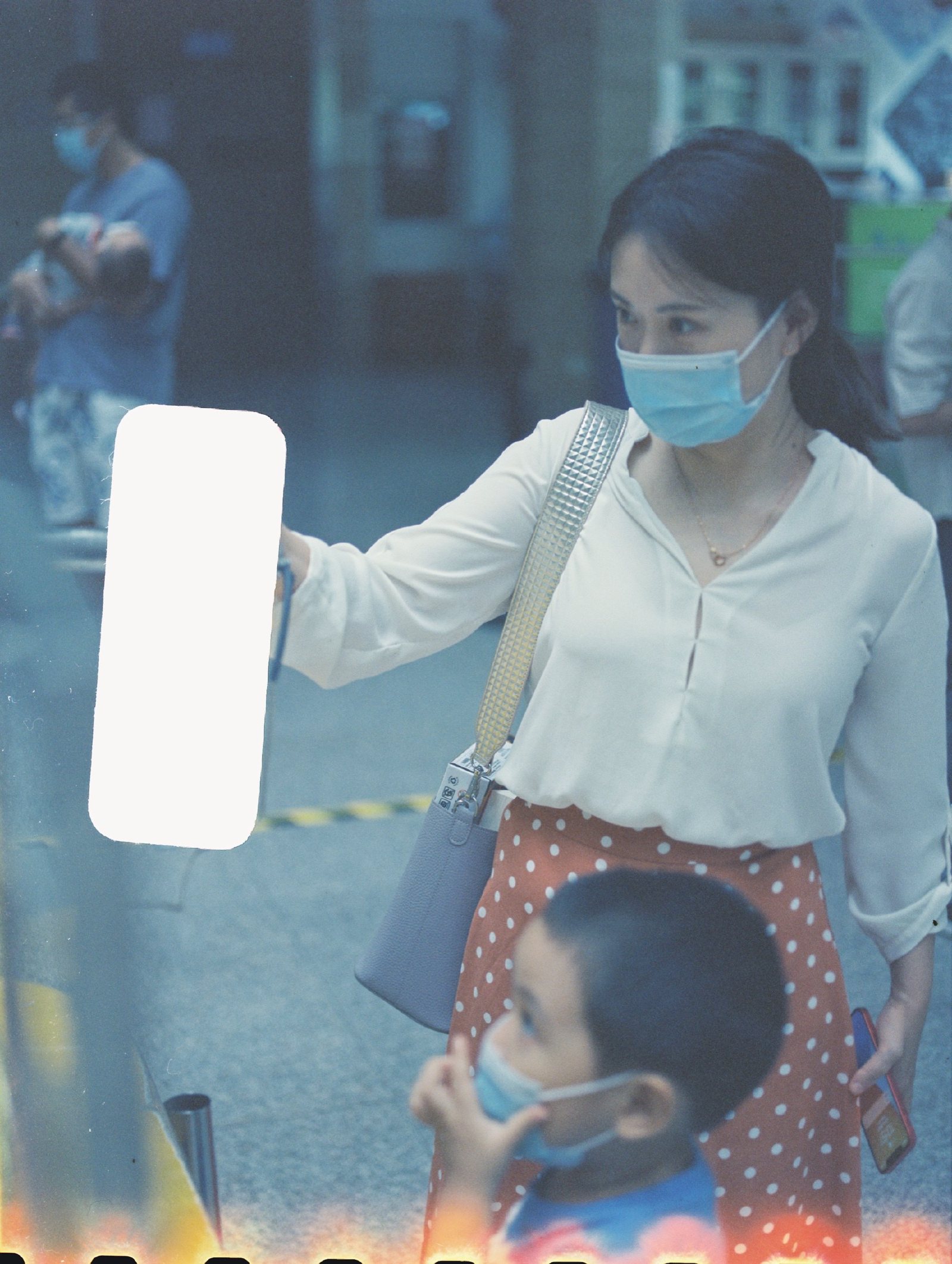 展馆里妈妈举着一块白板，儿子站在她身前
