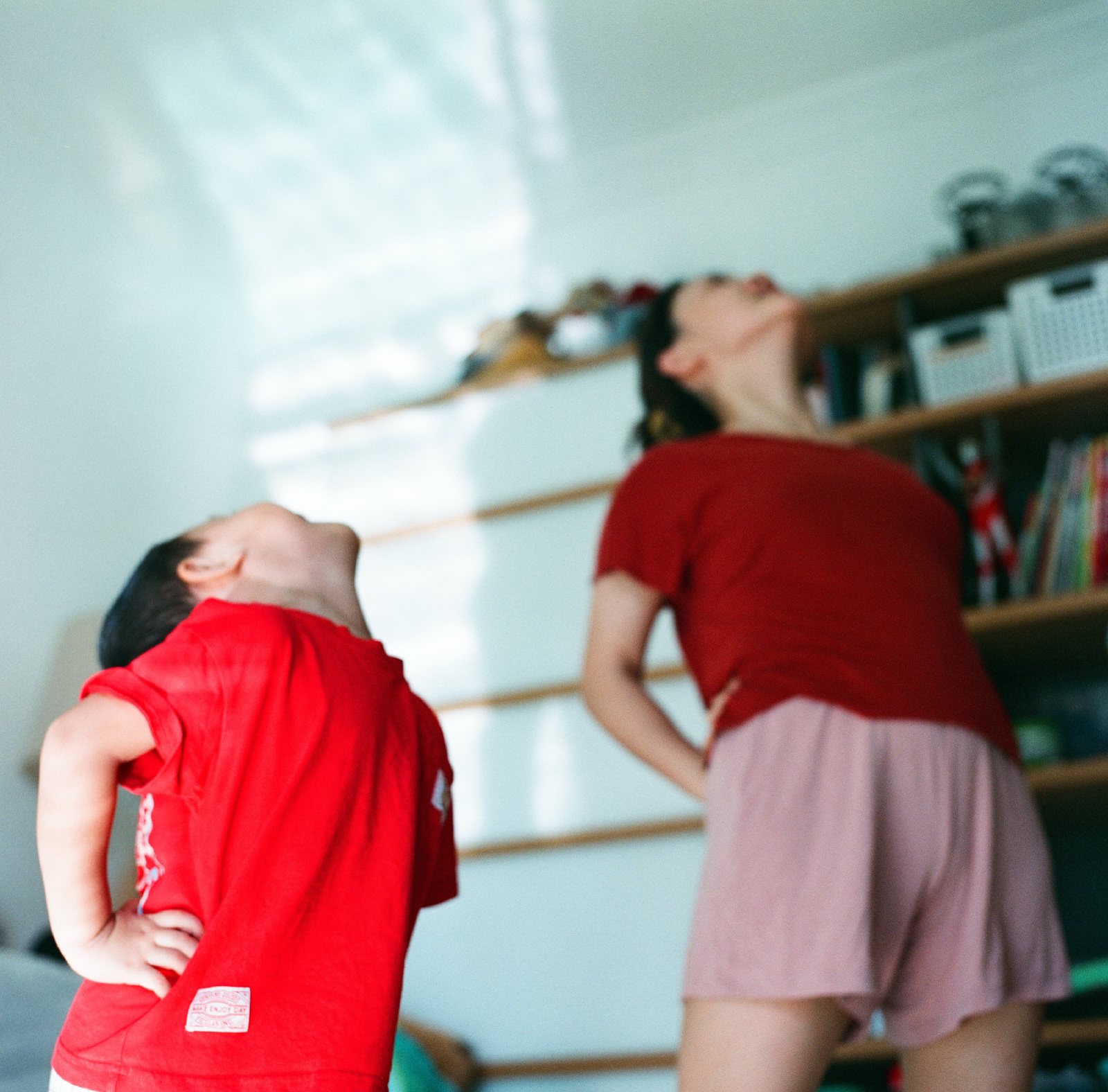 儿子和他妈妈在客厅里一起叉腰，向后仰头